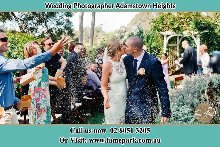 Photo of the people cheering as they watch the newly weds kissed Adamstown Heights