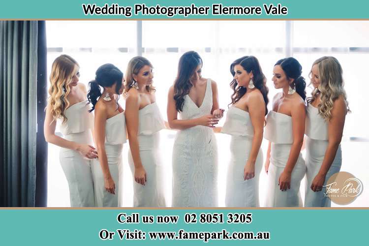 Photo of the Bride with her bridesmaids looking at her Elermore Vale NSW 2287