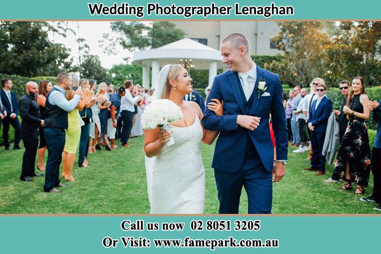 The new couple happily walks away from the wedding venue while being cheered by their loved ones Lenaghan