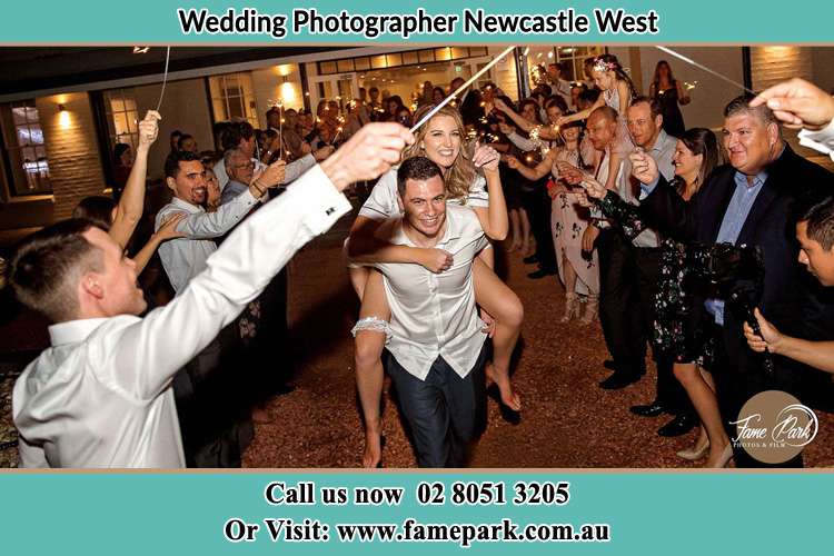 Photo of the Groom Carrying her Bride as their loved ones cheered on Newcastle West